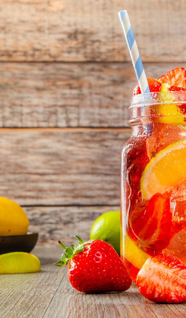 Напиток с клубникой и лимоном в банке на столе 