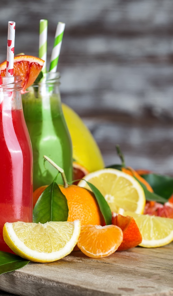Фруктовое смузи на столе в бутылках с трубочками