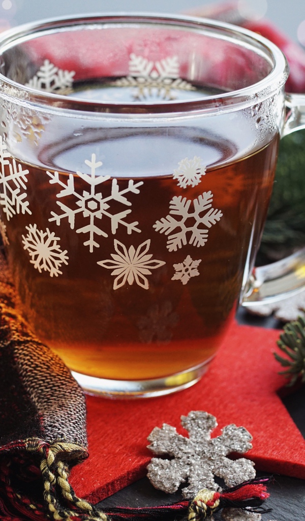 Стеклянная чашка чая на столе с ветками ели и шарфом 