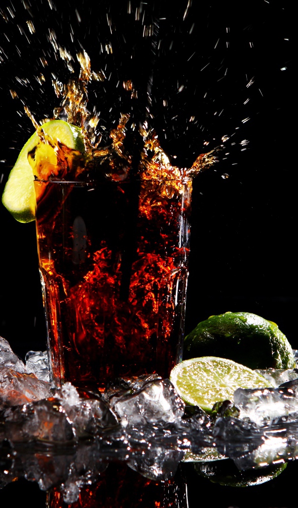 Стакан кока колы на черном фоне со льдом