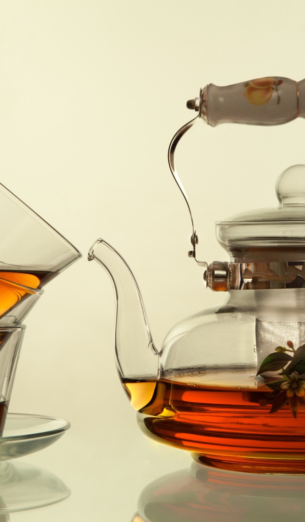 Стеклянный чайник с чашками на белом фоне