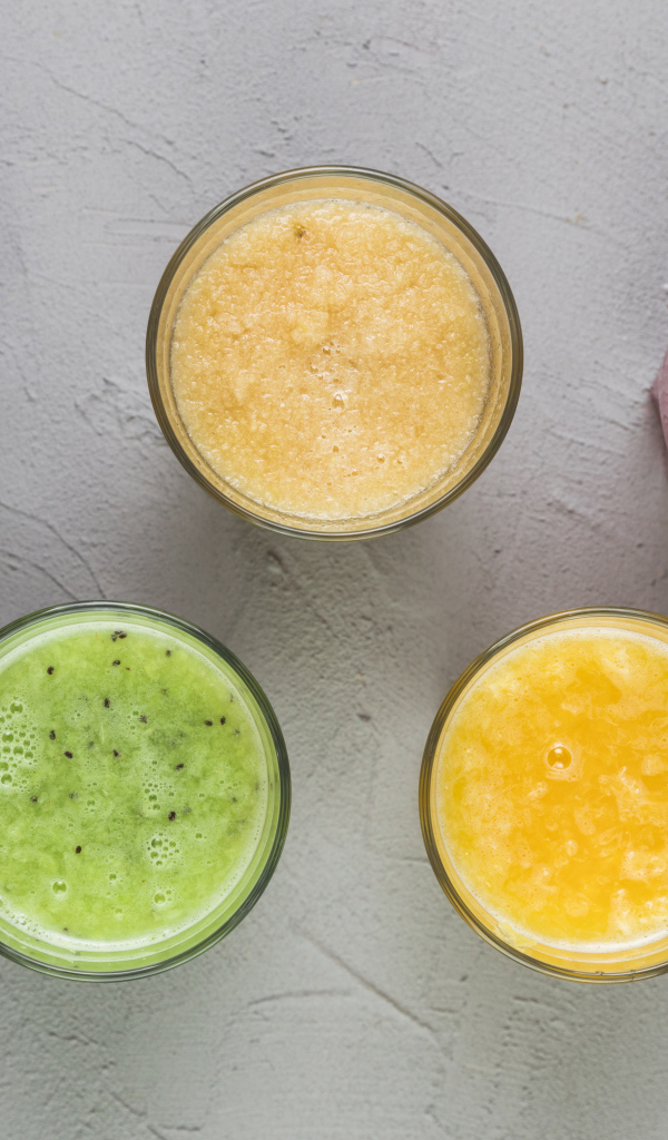 Стаканы с вкусным смузи на сером фоне