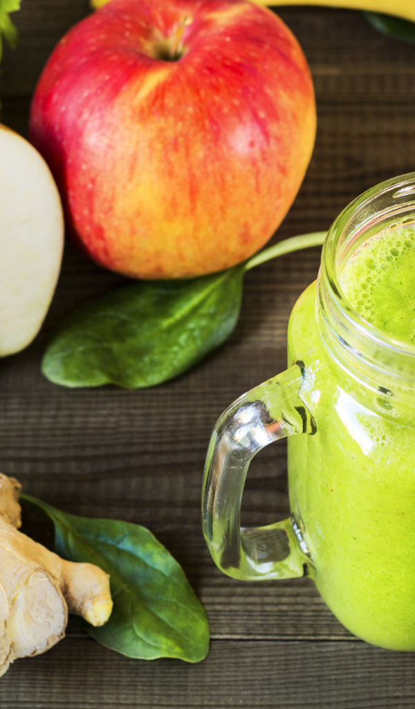 Зеленый смузи на столе с яблоками и имбирем