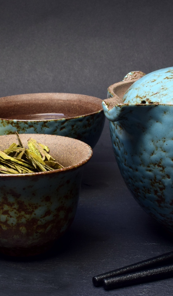 Зеленый чай на столе с посудой и лаймом