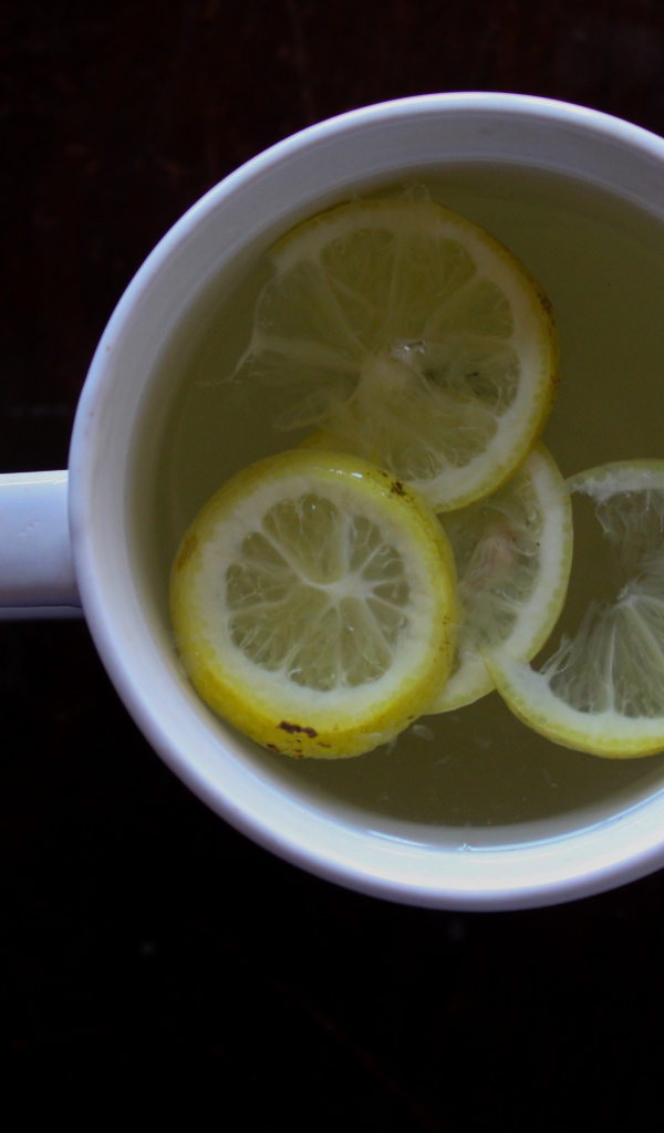 Зеленый чай с лимоном на черном фоне