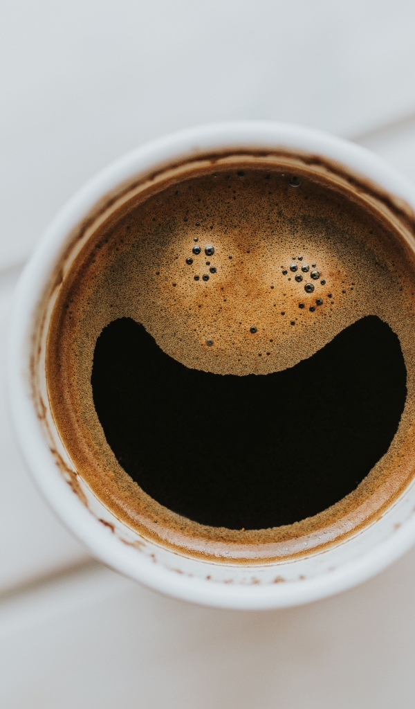 Улыбка на кофейной пенке в белой чашке