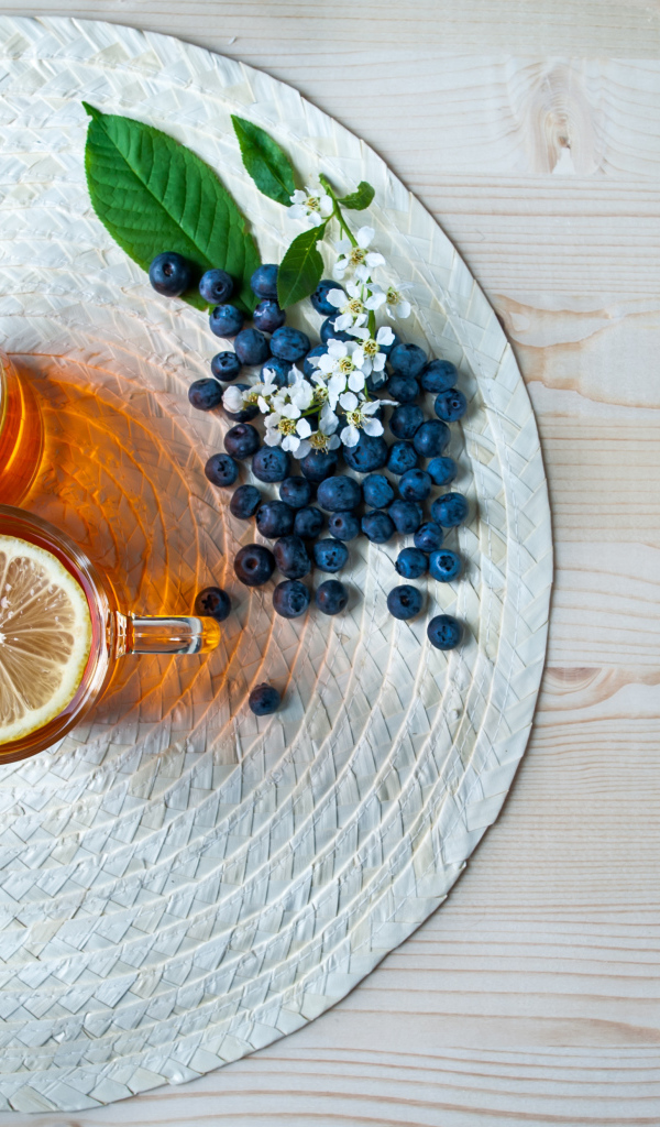 Чай с лимоном на столе с ягодами клубники и черники