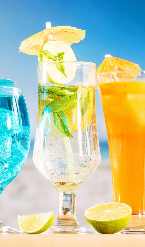 Три вкусных тропических коктейля стоят на пляже