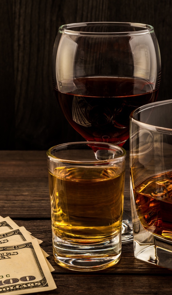 Три сосуда  с виски на столе с долларами