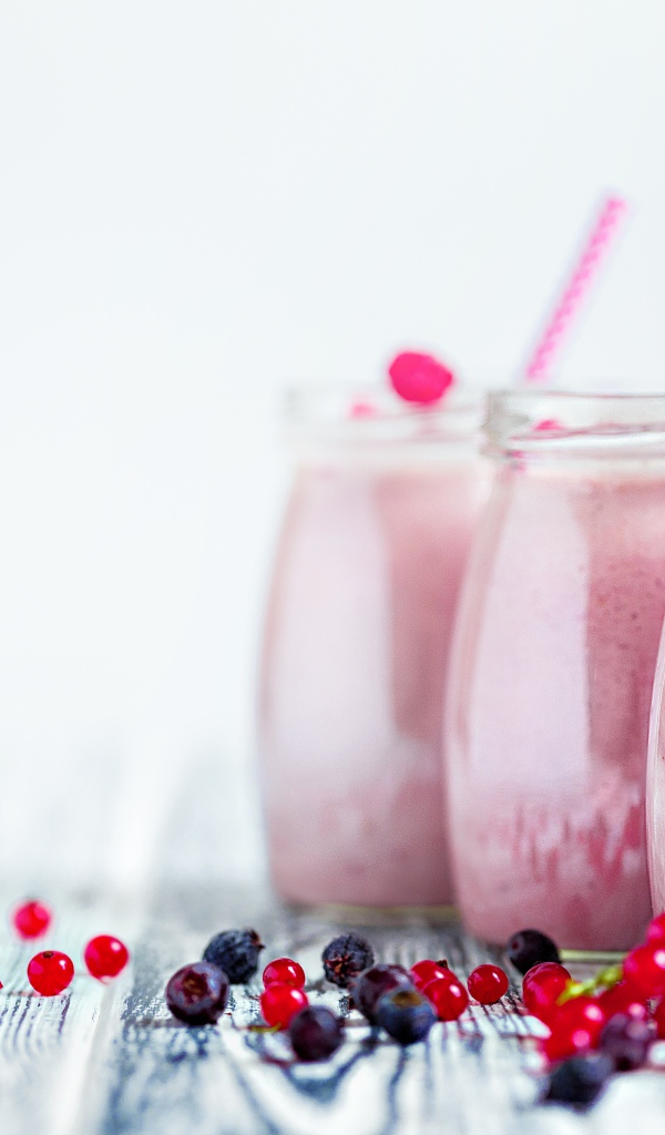 Три банки с ягодным смузи на белом фоне