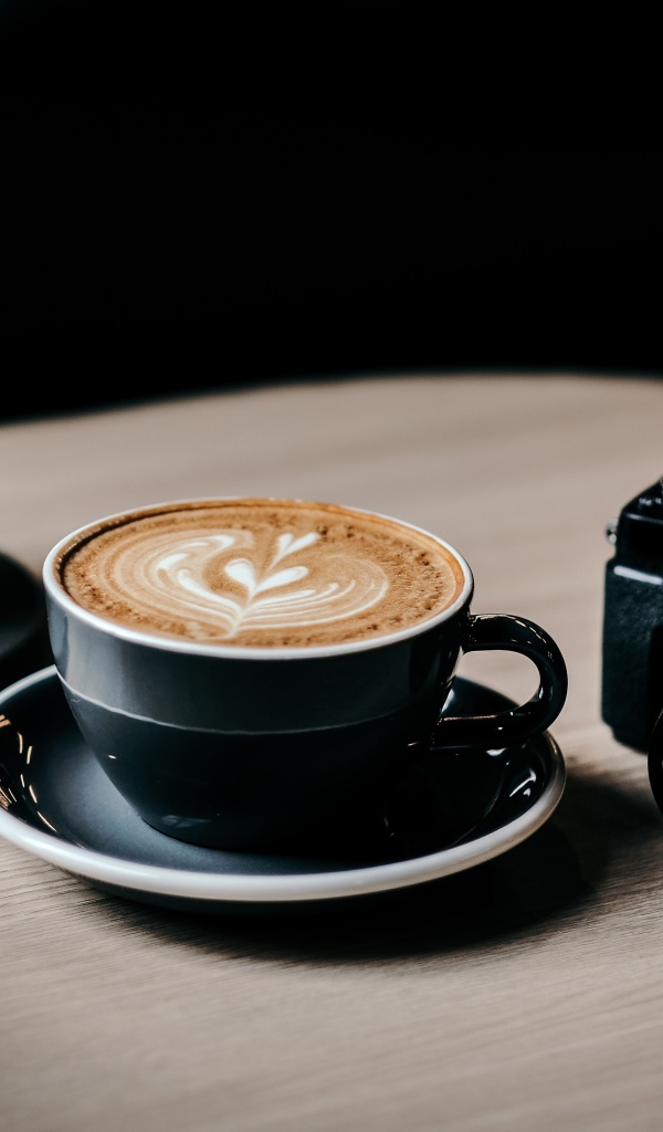 Две чашки кофе на столе с фотоаппаратом 