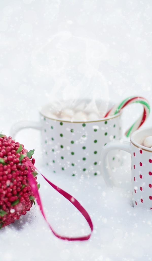 Две чашки горячего какао с маршмеллоу на снегу 