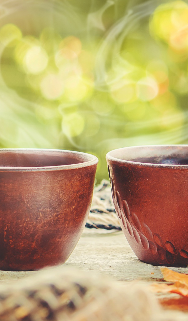 Два чашки горячего кофе с паром на столе осенью 