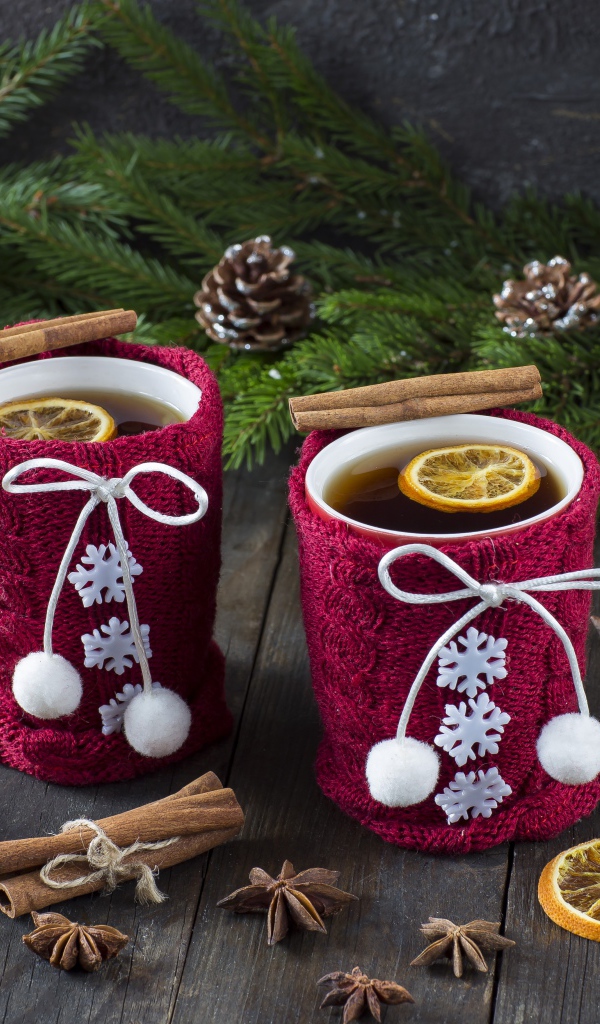 Две чашки горячего чая с лимоном на столе с еловыми ветками