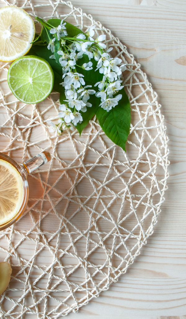 Две чашки чая с лимоном на плетеной подставке 