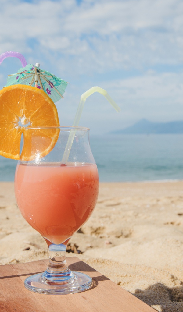 Два тропических коктейля на пляже в лучах солнца