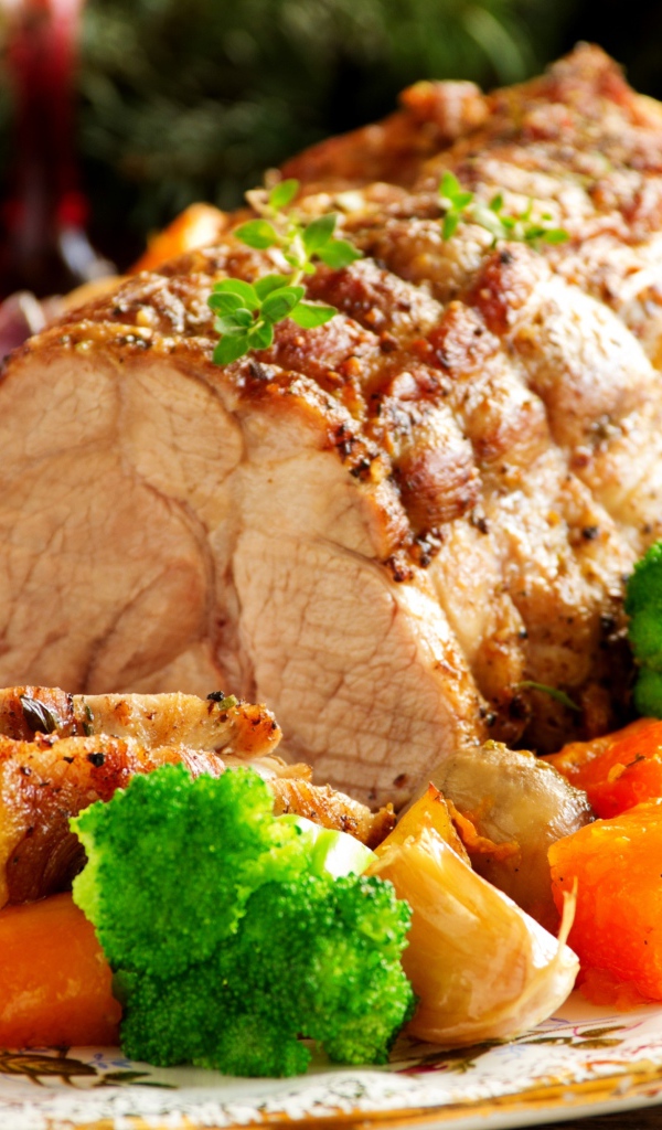 Кусок запеченного мяса на тарелке с овощами