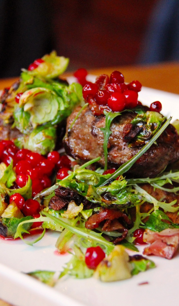 Кусок жареного мяса с салатом на тарелке