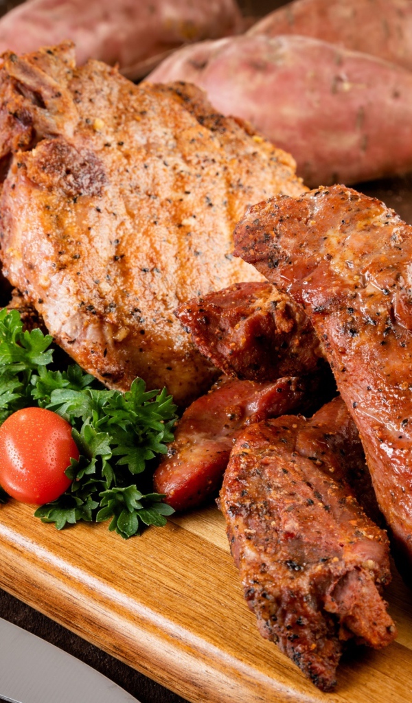 Аппетитное запеченное мясо на столе с чесноком и картофелем