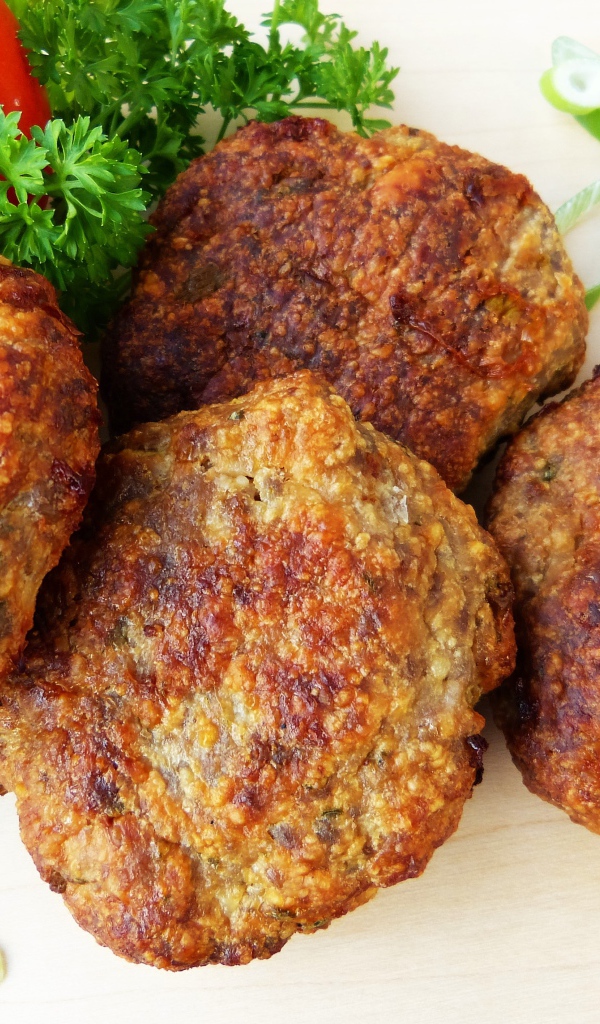 Аппетитные котлеты на тарелке с помидорами и петрушкой