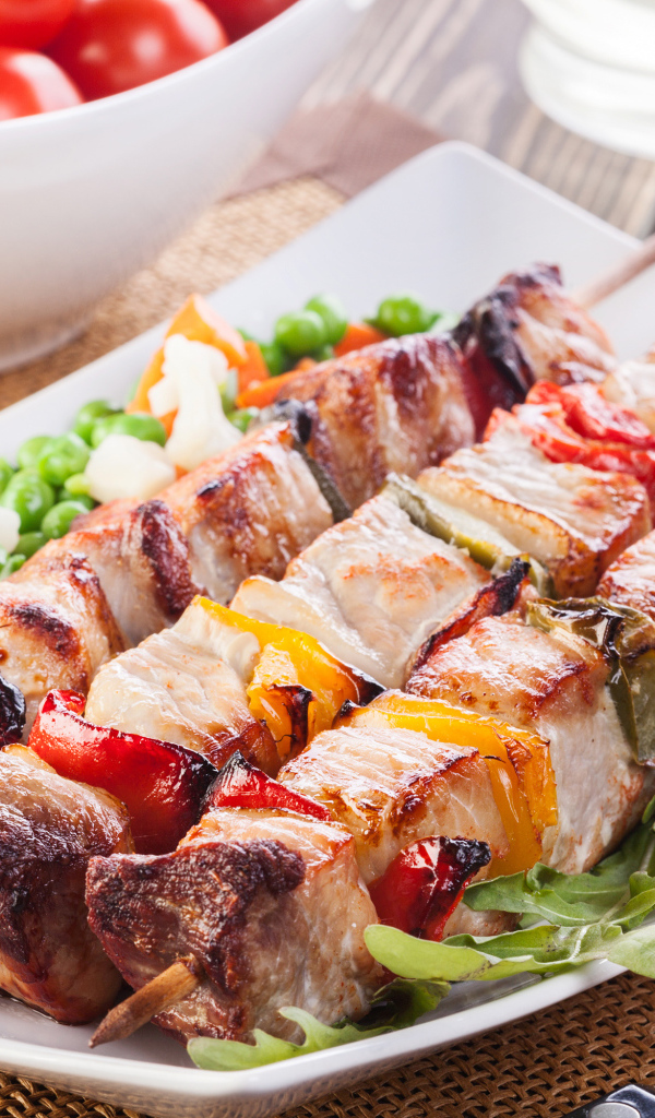 Аппетитный шашлык на тарелке с горохом