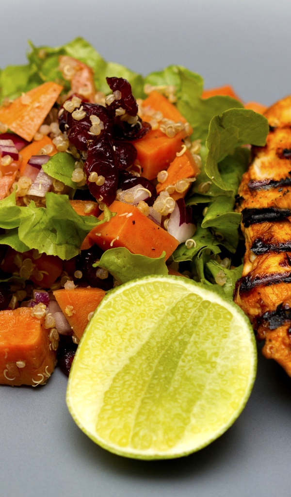 Запеченная куриная грудка с овощами и лаймом на тарелке 