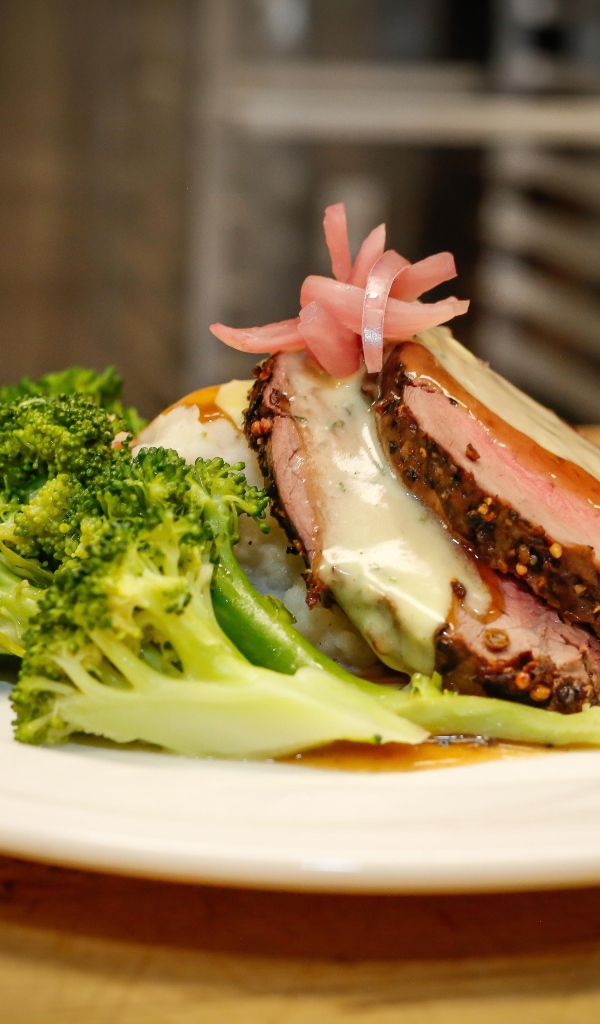 Брокколи на тарелке с кусочками запеченного мяса 