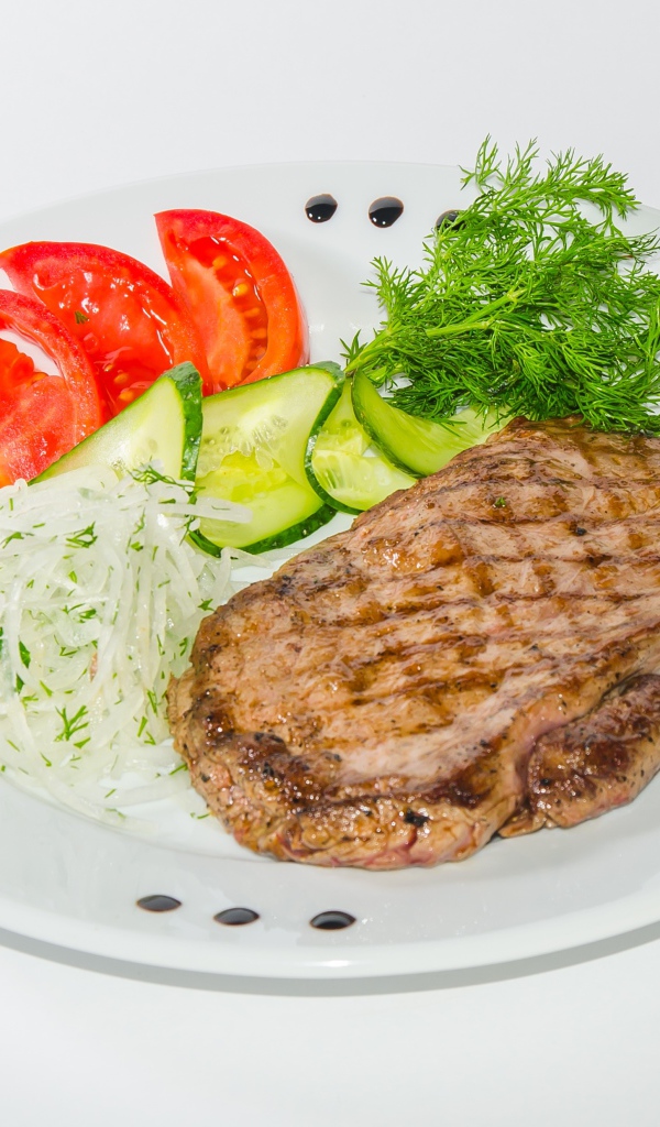 Кусок курицы с овощами на белой тарелке 