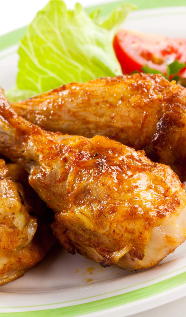 Зажареные куриные ножки на тарелке с овощами