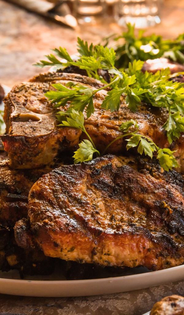 Много жареного мяса на тарелке с петрушкой 