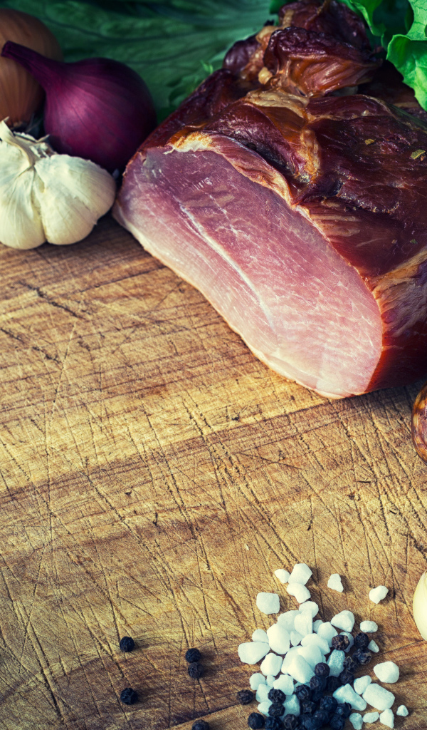 Мясные продукты на столе со специями, луком и чесноком 