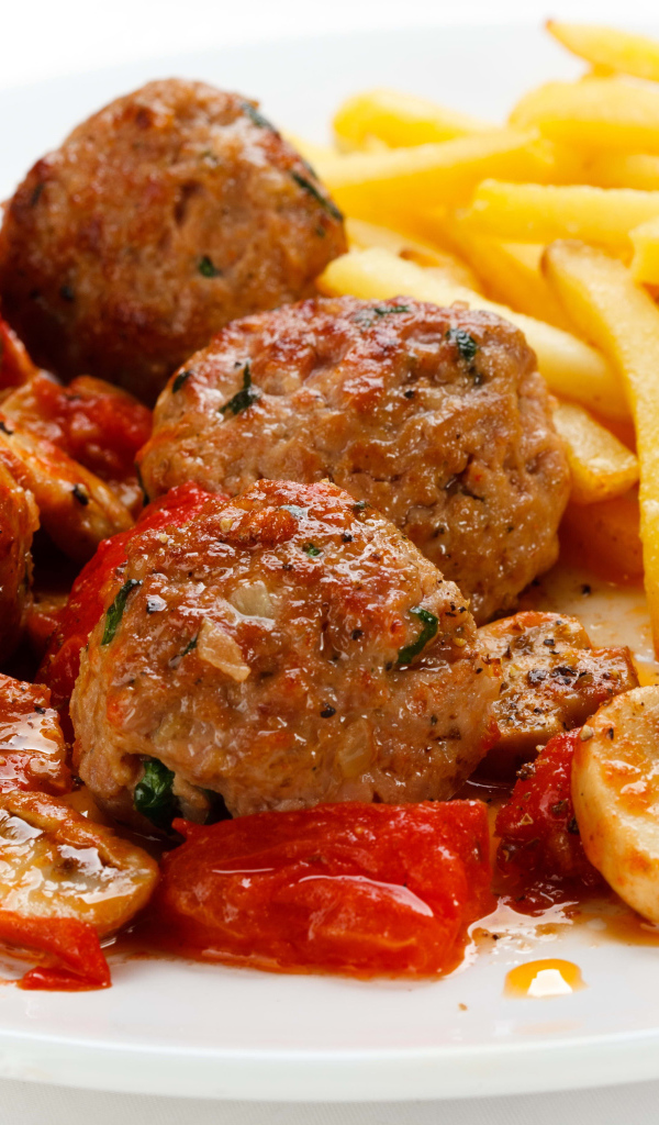 Тефтели с картофелем фри и овощами на белом фоне