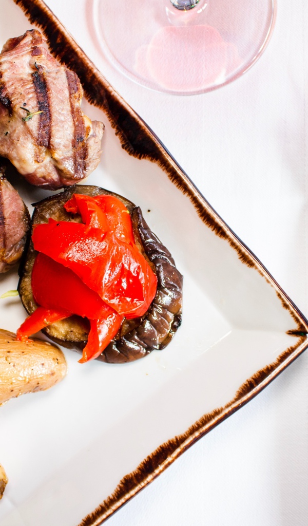 Свиные ребрышки с овощами на столе 