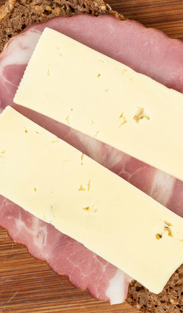 Бутерброд с ветчиной и сыром на доске 