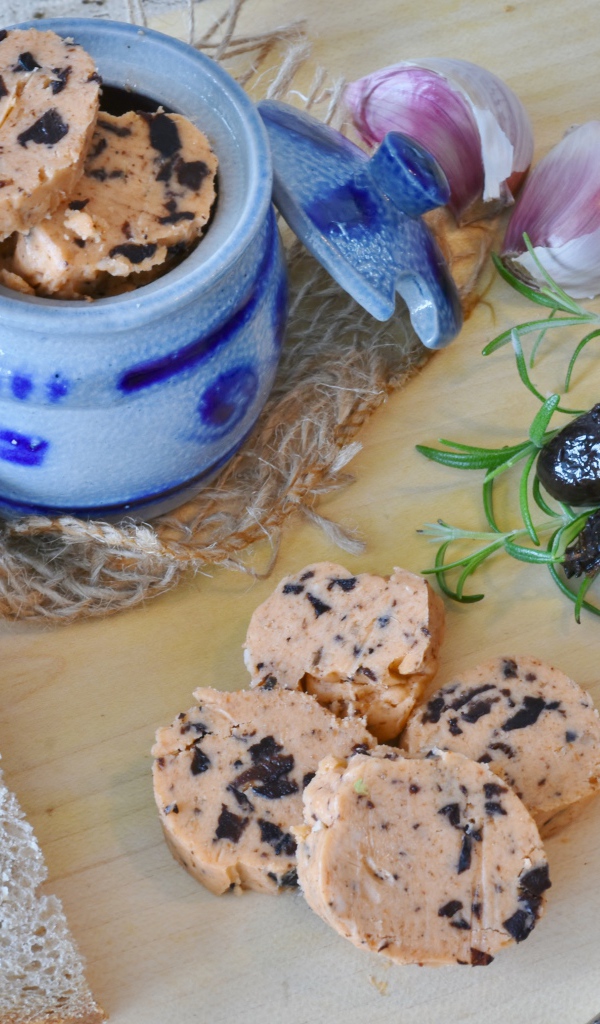 Колбаса с маслинами на столе с хлебом и чесноком