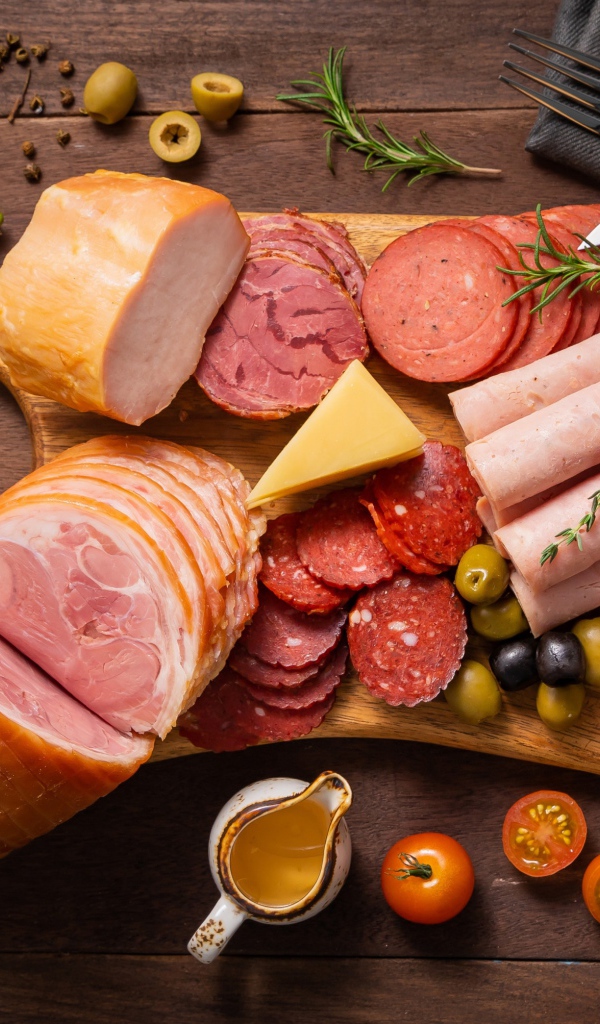 Колбасы и мясные продукты на доске со специями