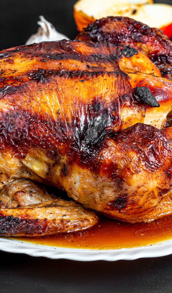 Вкусная запеченная курица на белой тарелке на столе с овощами