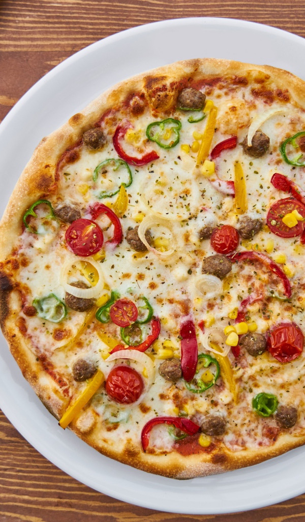 Аппетитная вкусная пицца на столе с овощами 