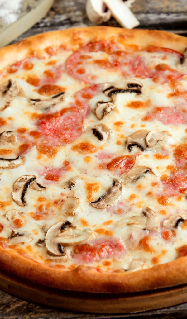 Вкусная пицца с грибами, колбасой и сыром