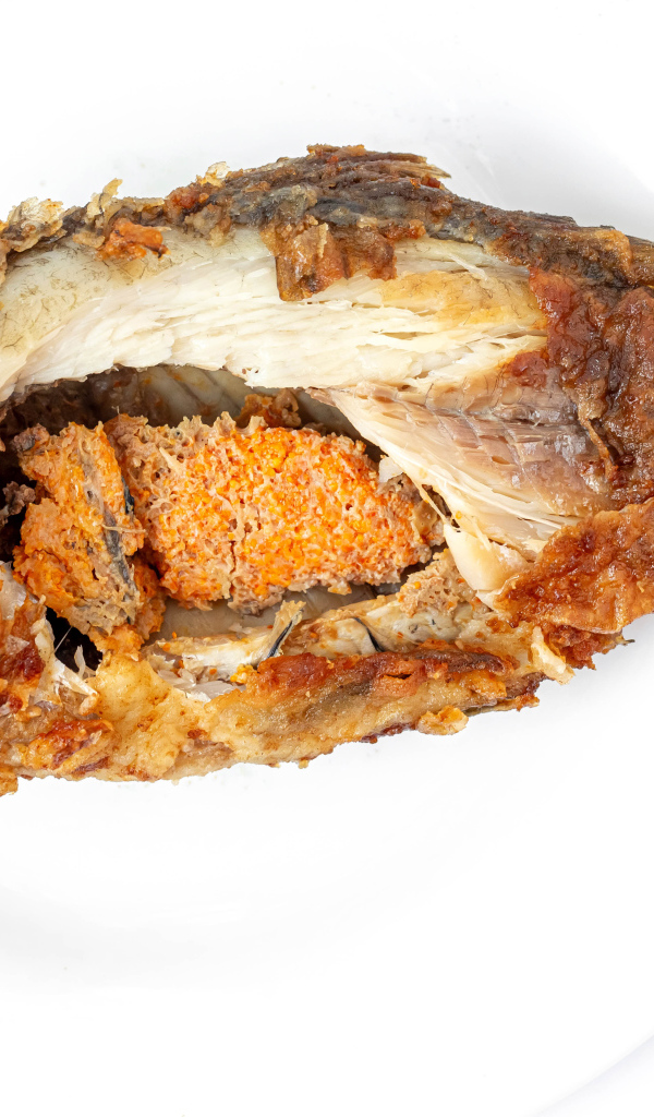 Жареная рыба с икрой внутри на белом фоне