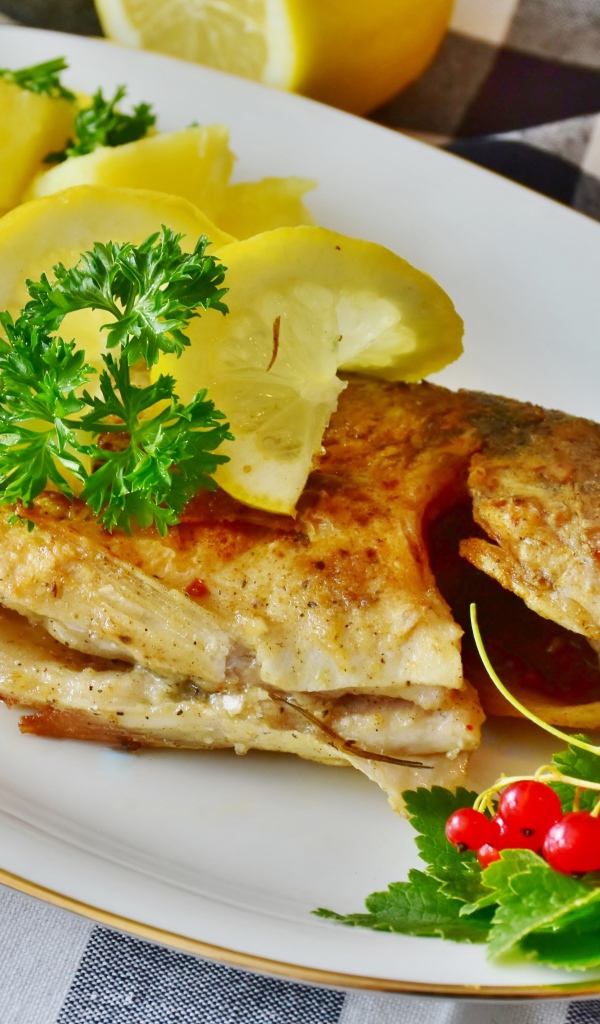 Жареная рыба с лимоном на тарелке с картофелем