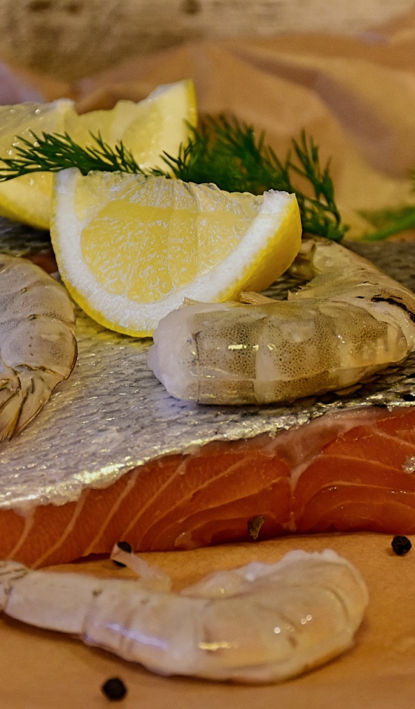 Кусок красной рыбы с креветками и лимонами