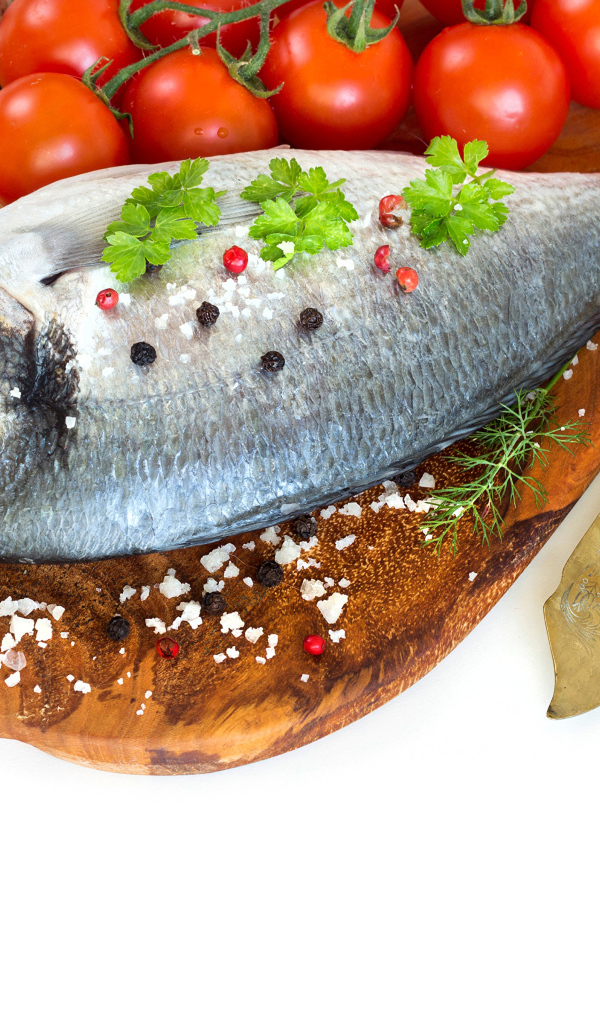 Сырая рыба на столе с маслом и помидорами 