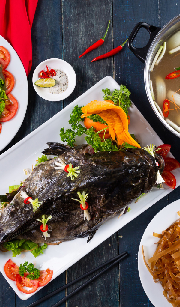 Фаршированная рыба на столе с овощами
