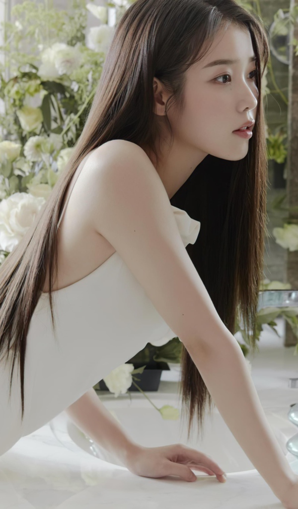 Красивая девушка азиатка в белом платье стоит у зеркала