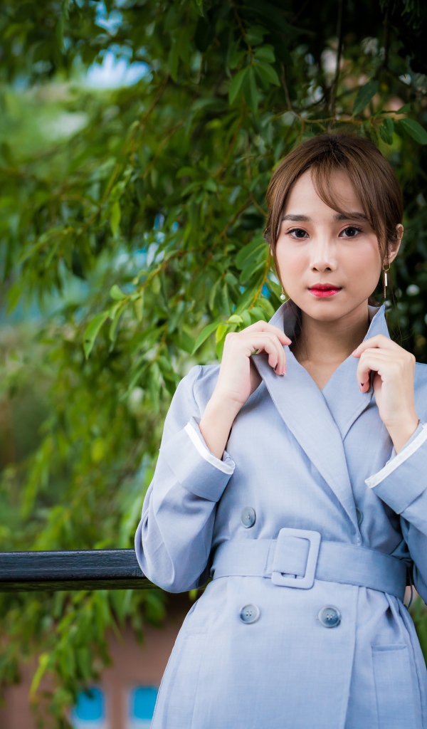 Девушка азиатка в голубом пальто в парке