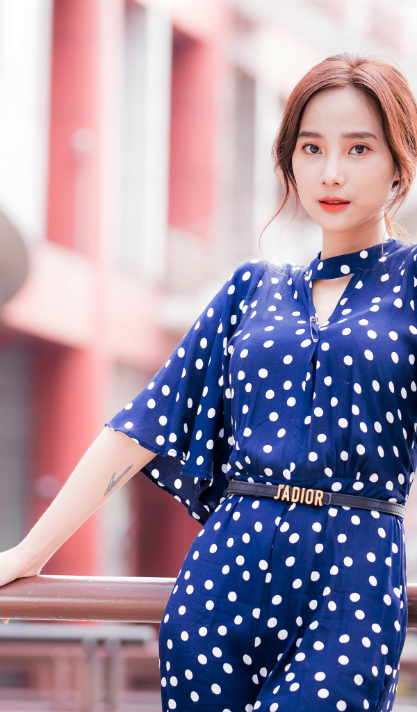 Девушка азиатка в синем платье в белый горошек