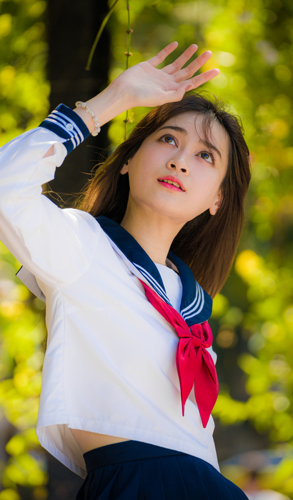 Девушка азиатка в форме с красным галстуком
