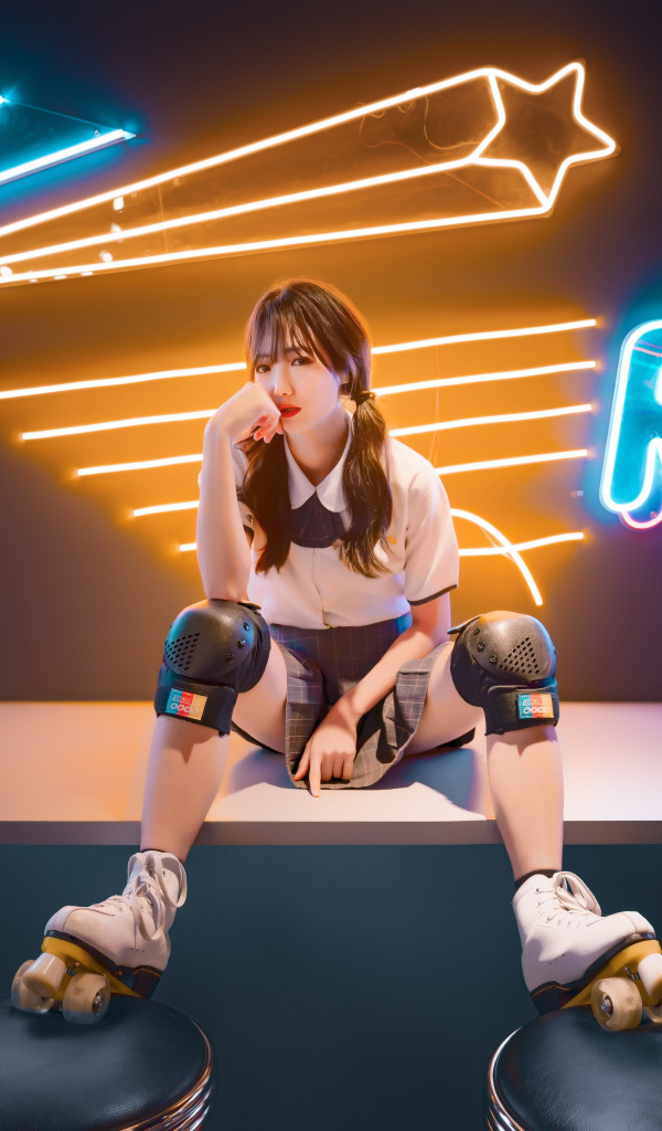 Девушка азиатка сидит в роликах на фоне вывески 