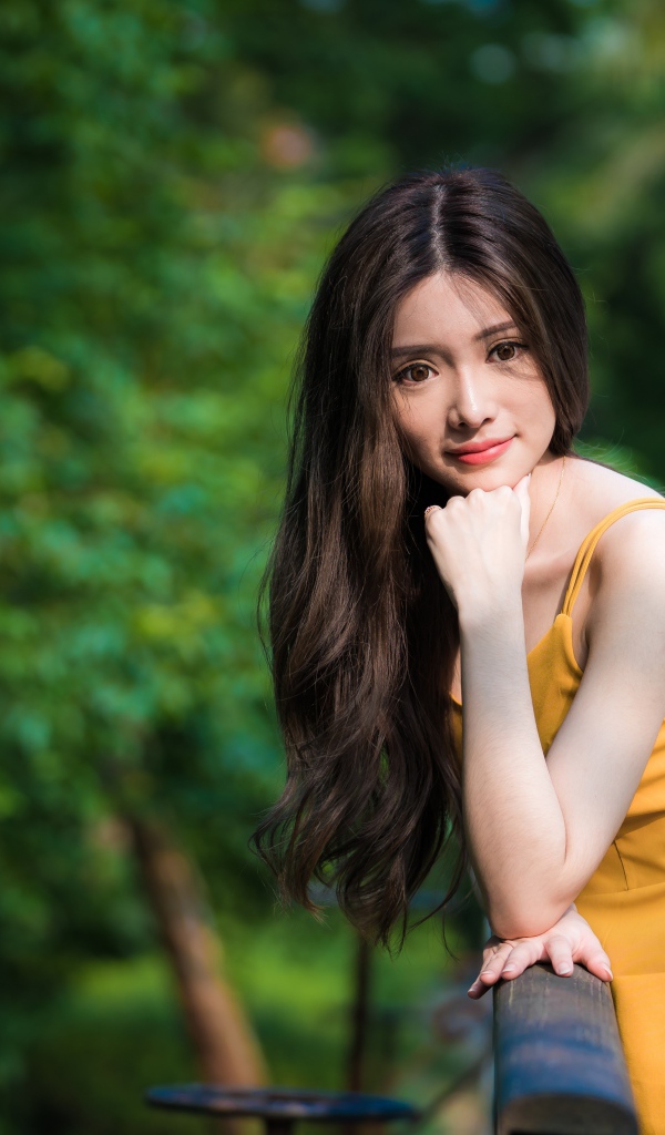 Девушка азиатка с большими карими глазами в желтом платье 